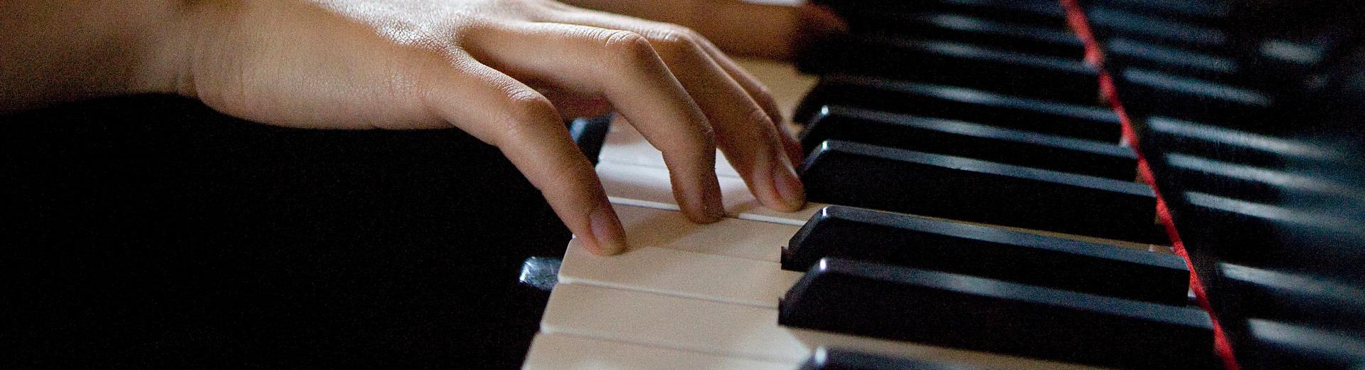 Six h和s on piano keys playing a song